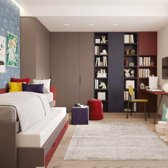 Camera da letto moderna con armadio grigio, scaffali a muro, dettagli rossi e letto accanto a un grande tappeto.