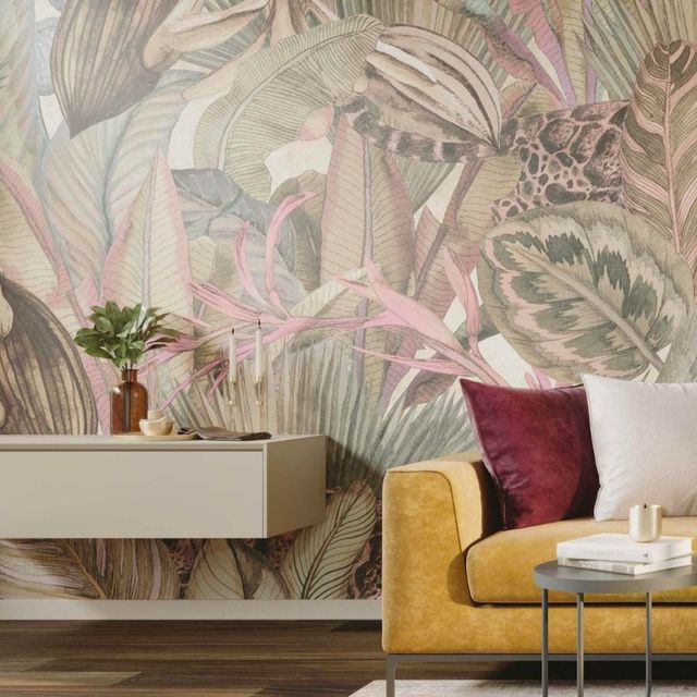 Soggiorno moderno con murale tropicale, divano color senape, tavolo in marmo e credenza beige.