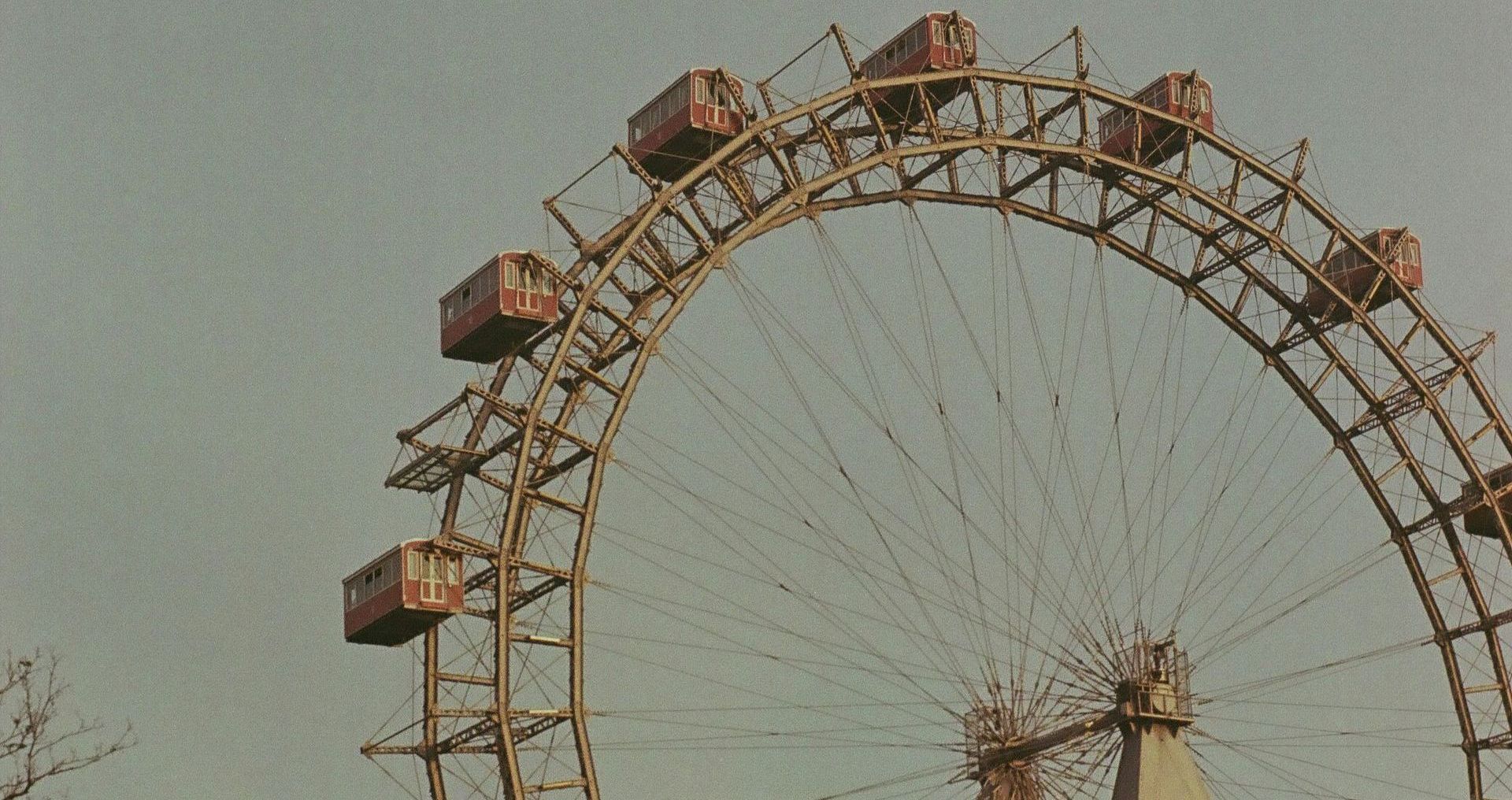 Close-up of the historic Giant Ferris Wheel in Vienna’s Prater amusement park on a cloudy day, with visible passenger cabins.