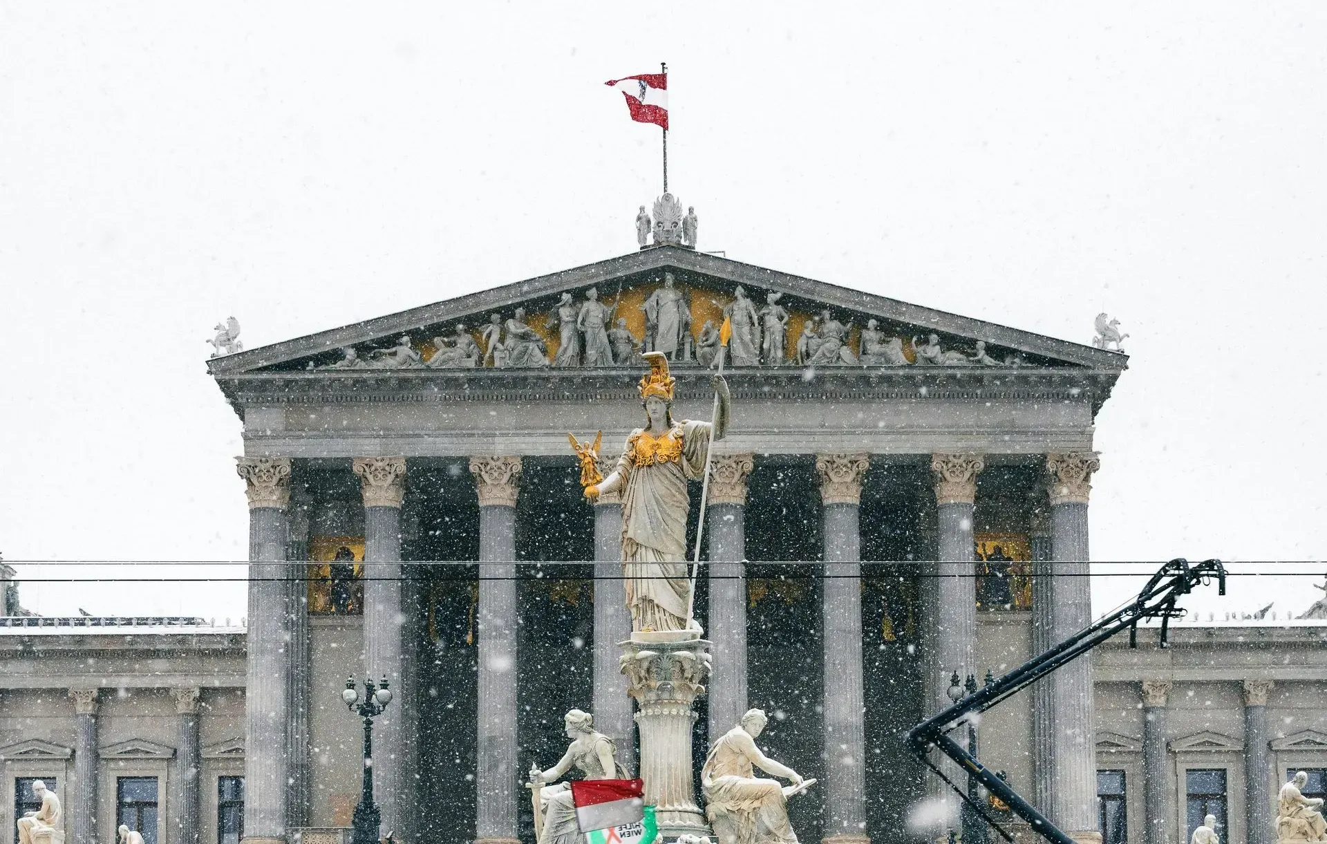 Austrian Parliament building covered in snowfall during winter—classic February scene and iconic Vienna landmark.