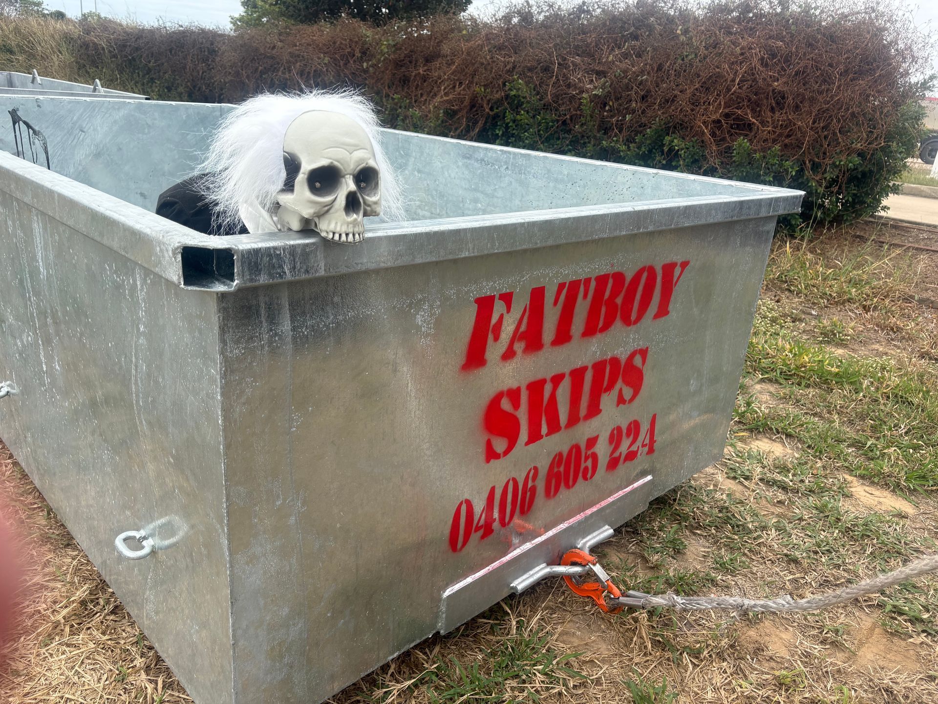 A Skull Prop With White Hair Sits in a Metal Skip Bin — Fat Boy Skips Townsville In Nome, QLD