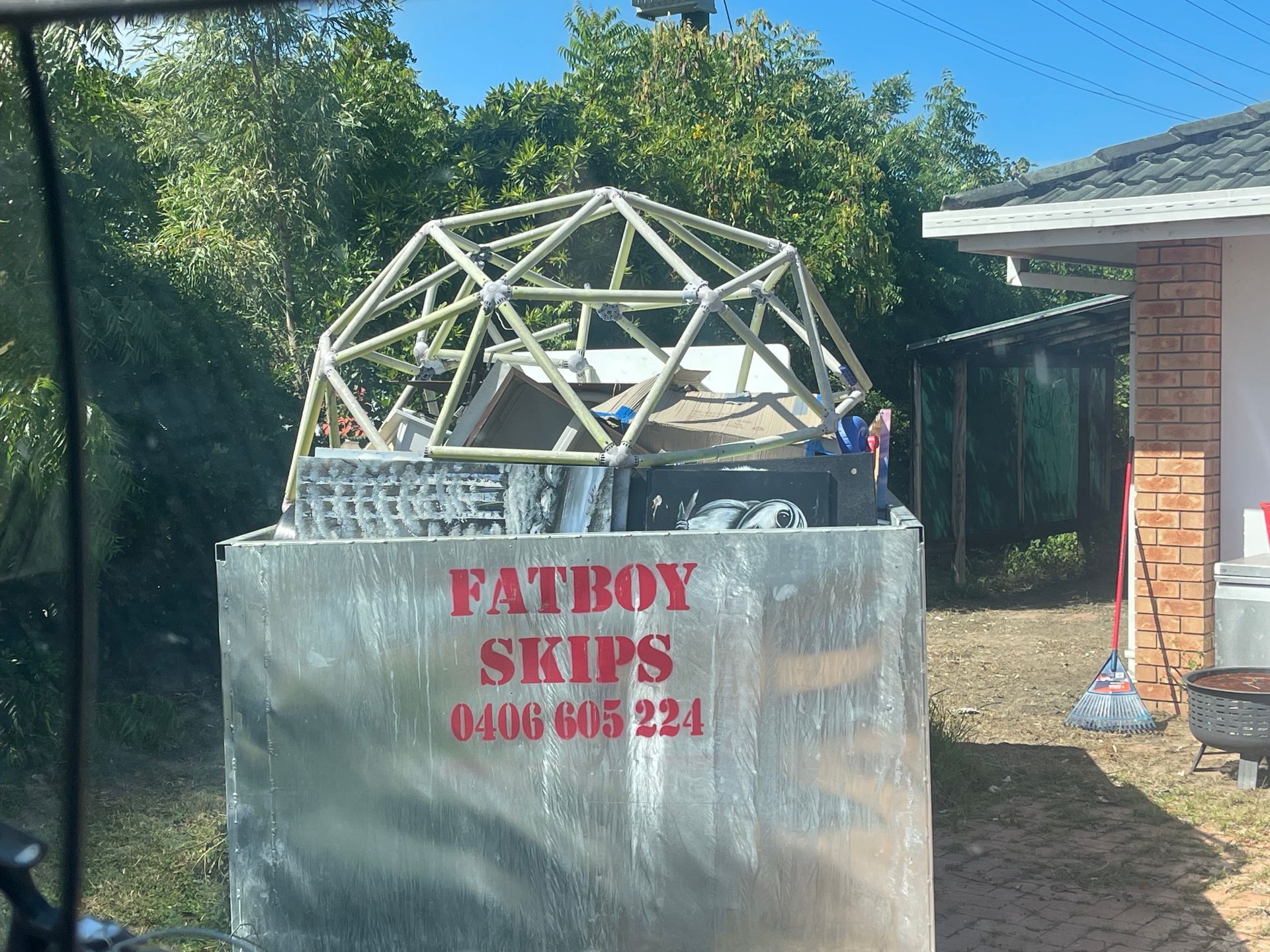 A Rusty, White Dumpster on A Sidewalk, Filled with Debris — Fat Boy Skips Townsville In Nome, QLD
