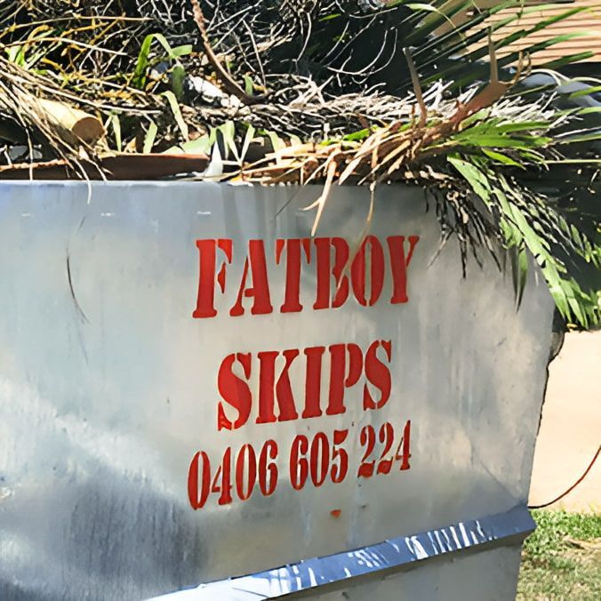 A Green Trash Can Filled With Leaves And Branches — Fat Boy Skips Townsville In Nome, QLD