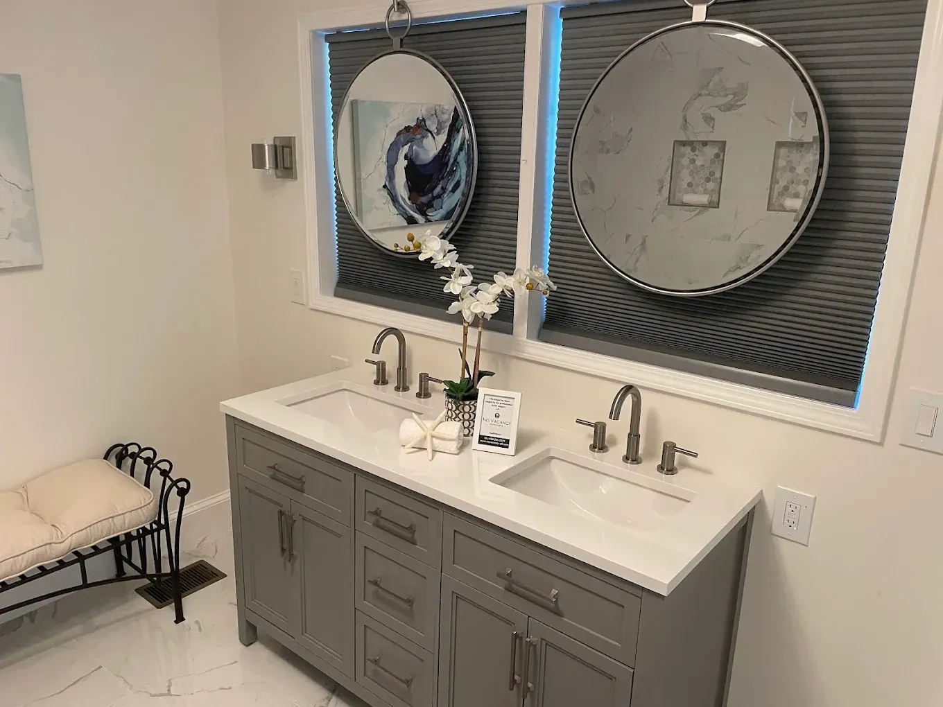 Modern bathroom vanity with double sinks, mirrors, and dark gray cabinets