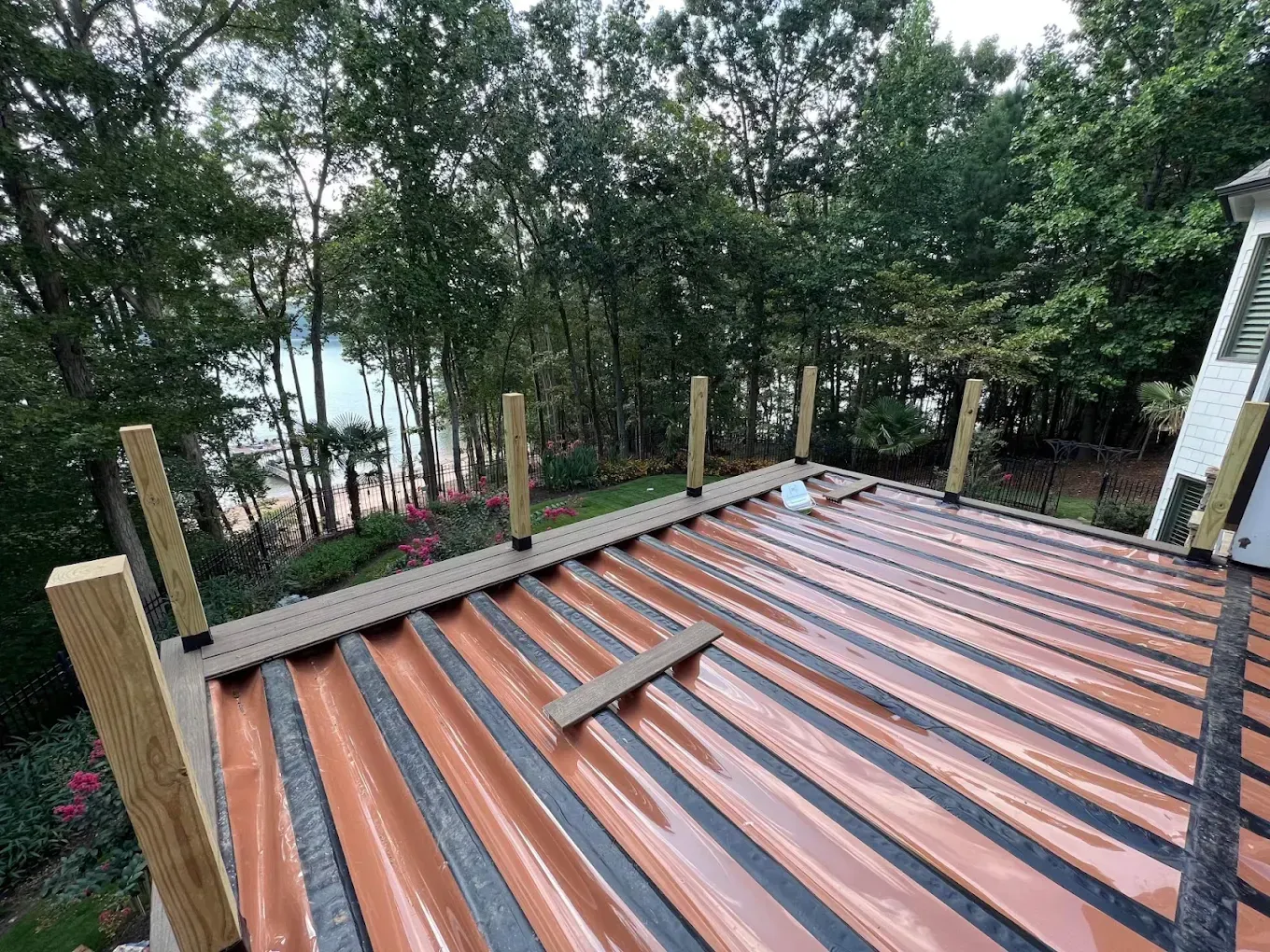 Metal roofing installed on a deck, with posts and trees in the background