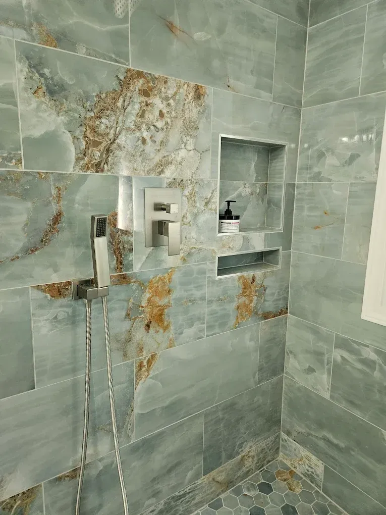 Modern tiled shower with built-in shelves and a chrome shower fixture
