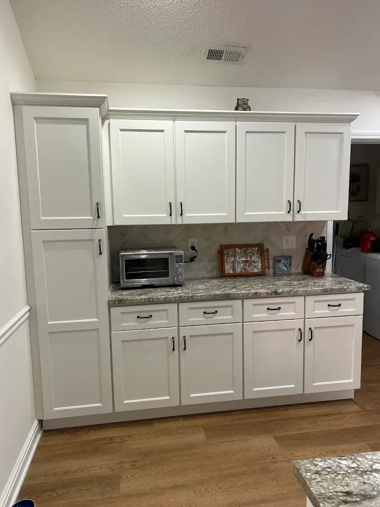 White kitchen cabinets with countertop appliances and wood floor