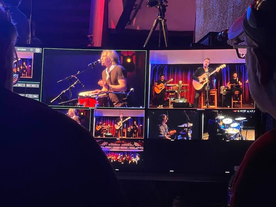 A group of people are watching a band perform on a stage