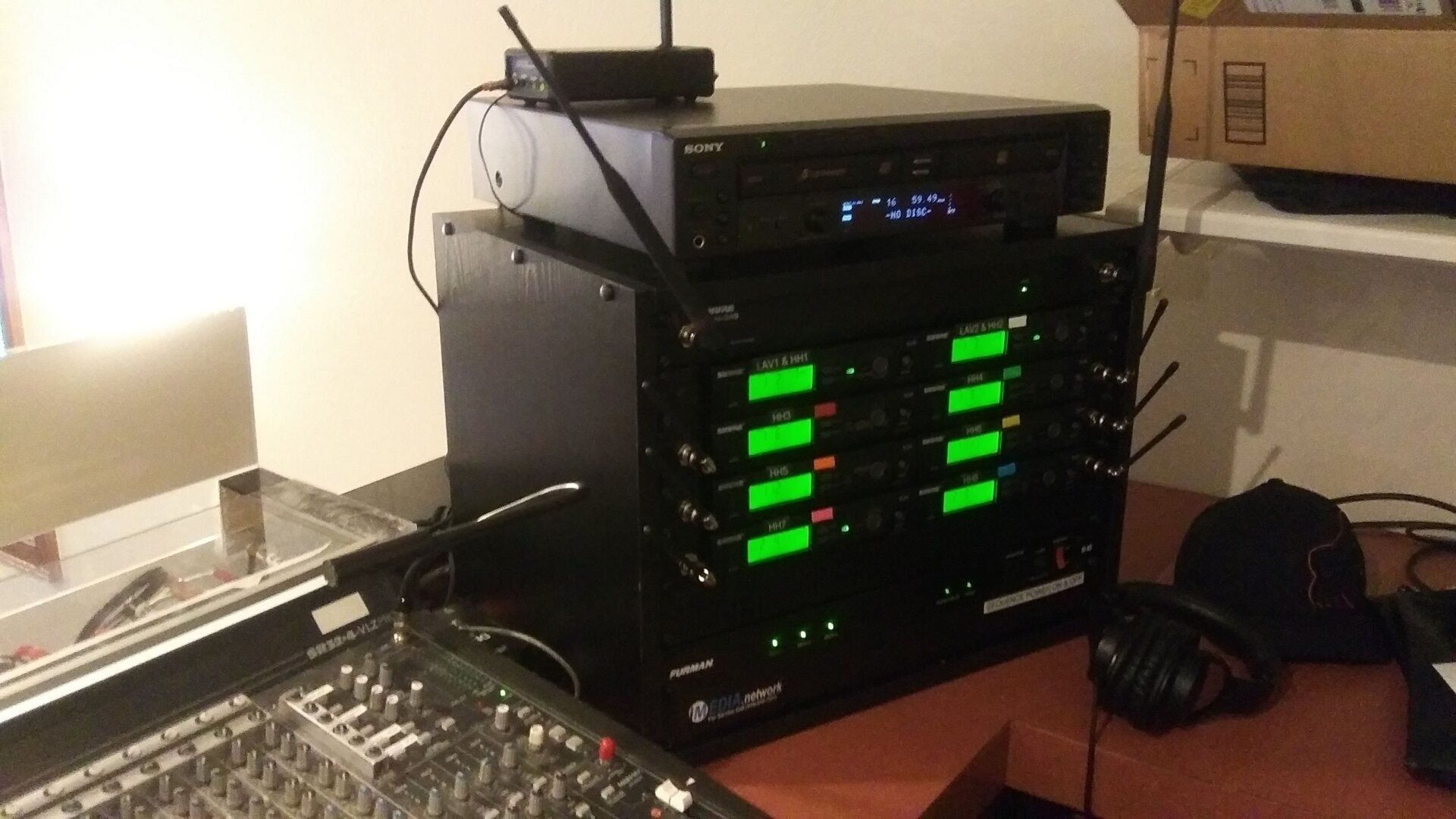 A stack of electronics with green lights on them