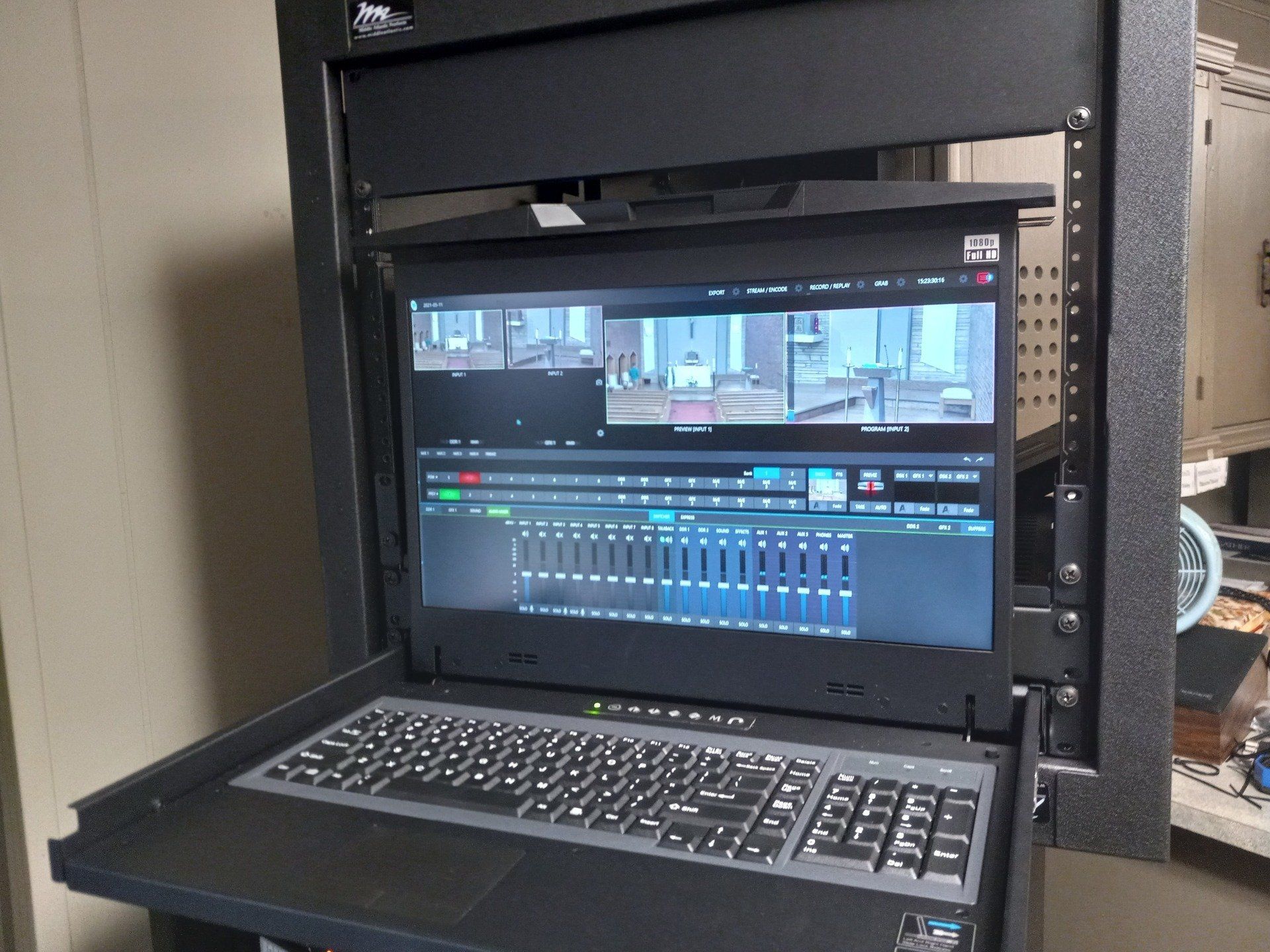 A laptop is sitting on top of a server rack