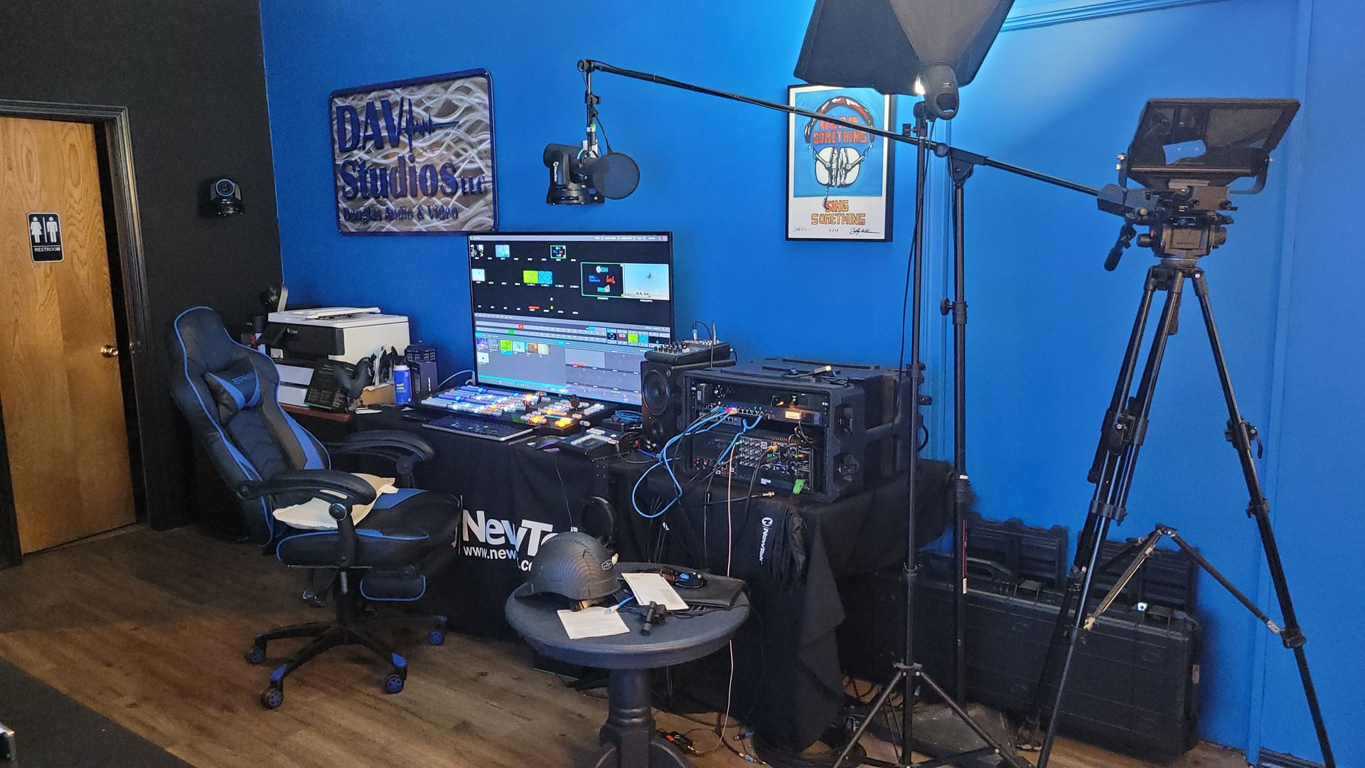 A room with a blue wall and a desk with a computer on it.