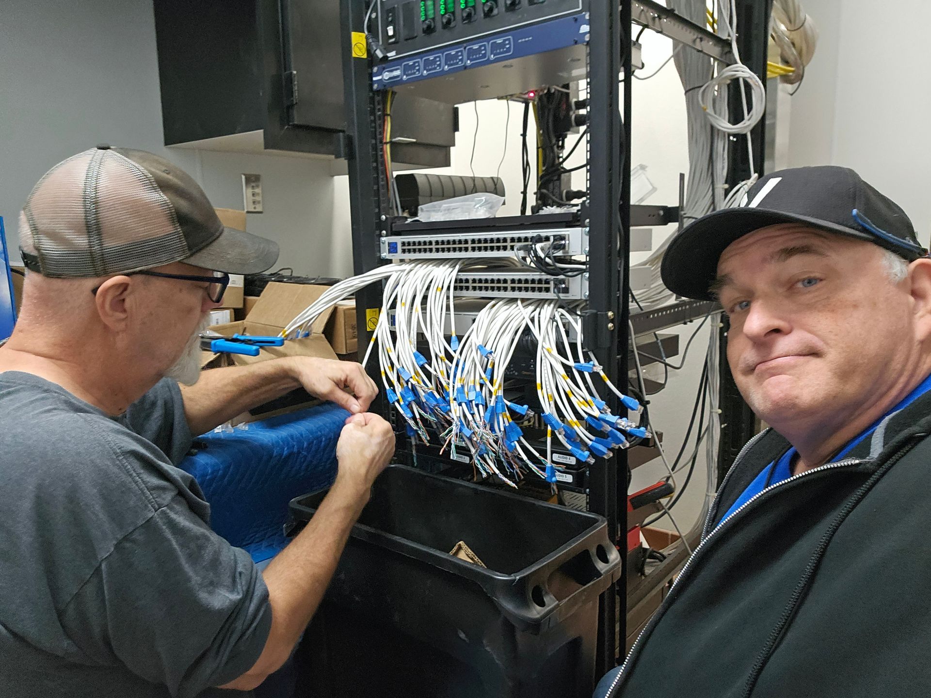 Two men are working on a server in a room.
