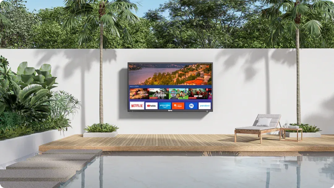 A flat screen tv is hanging on a wall next to a swimming pool.