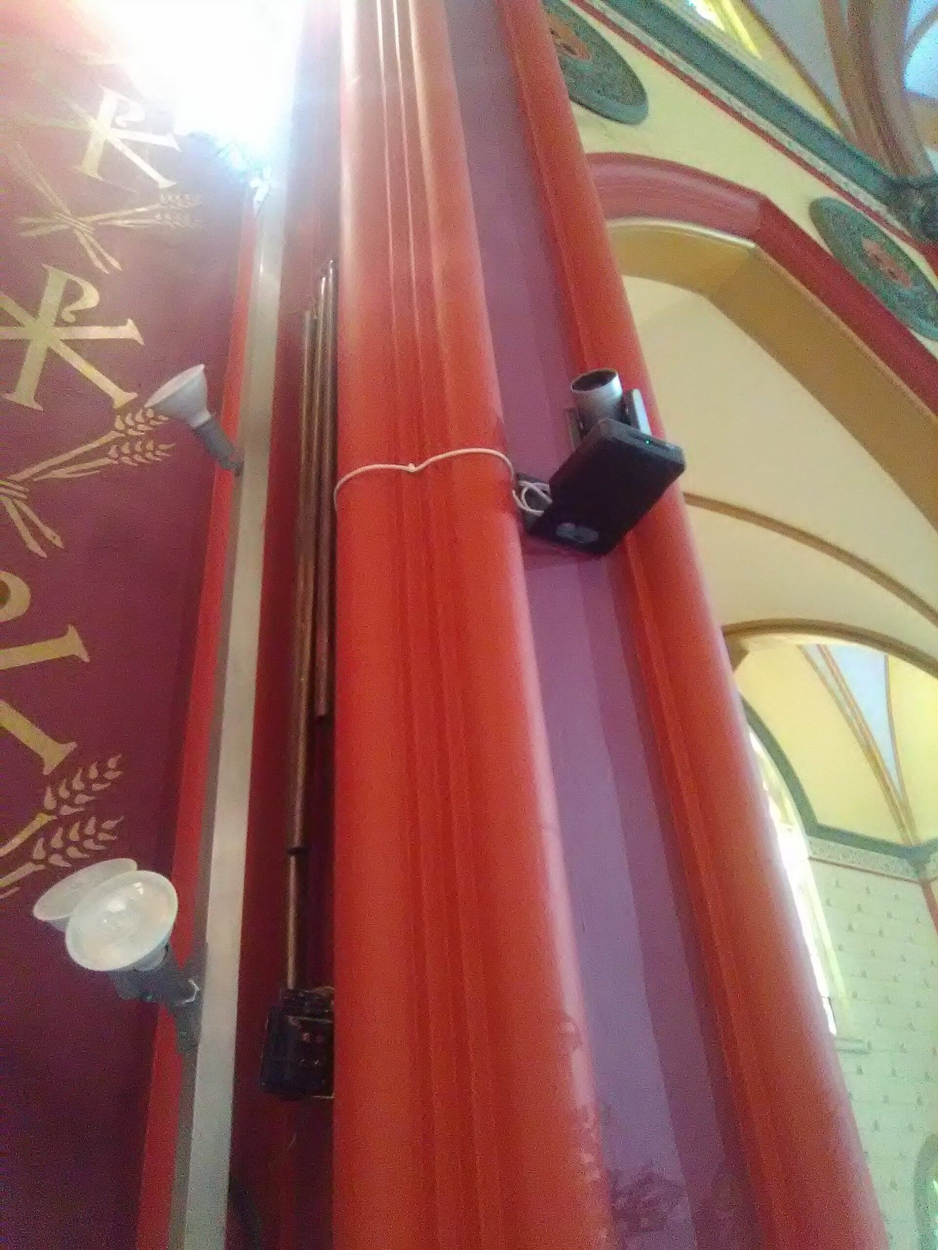 A red pipe with a camera attached to it in a church
