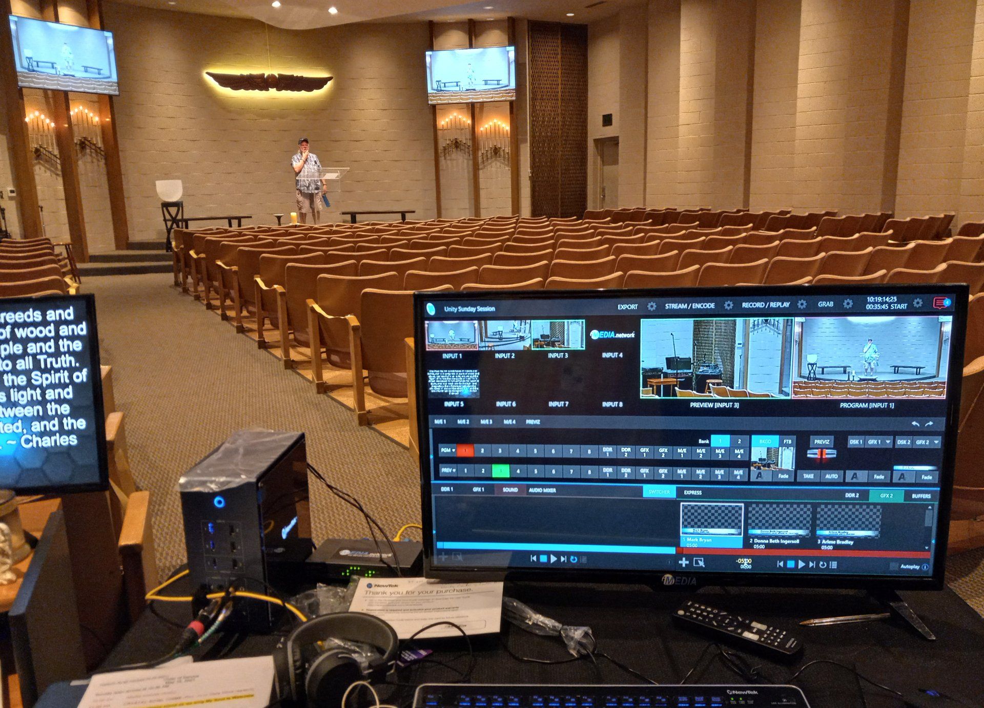 A computer monitor is sitting in front of a large auditorium.