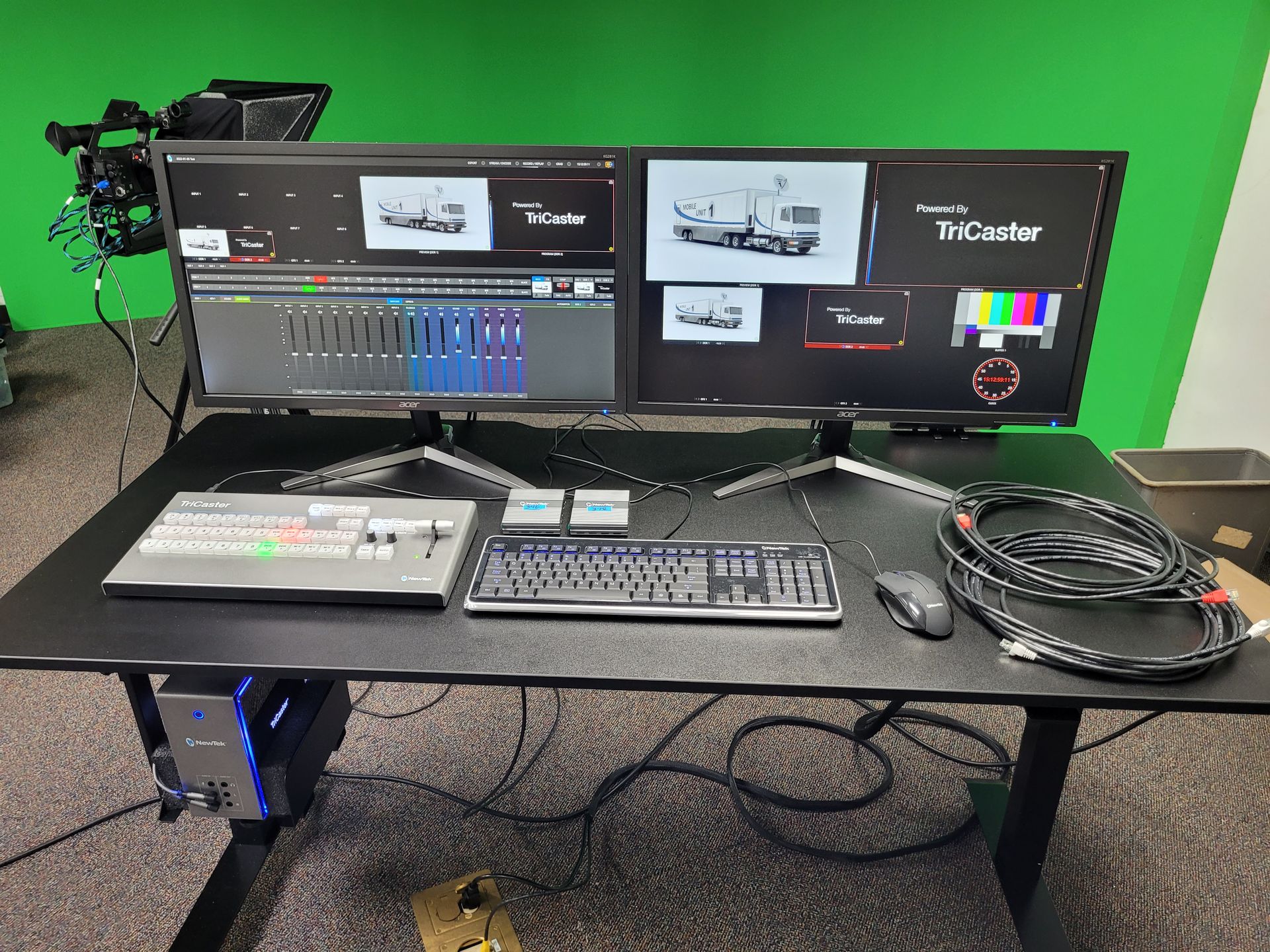 A desk with two monitors and a keyboard on it
