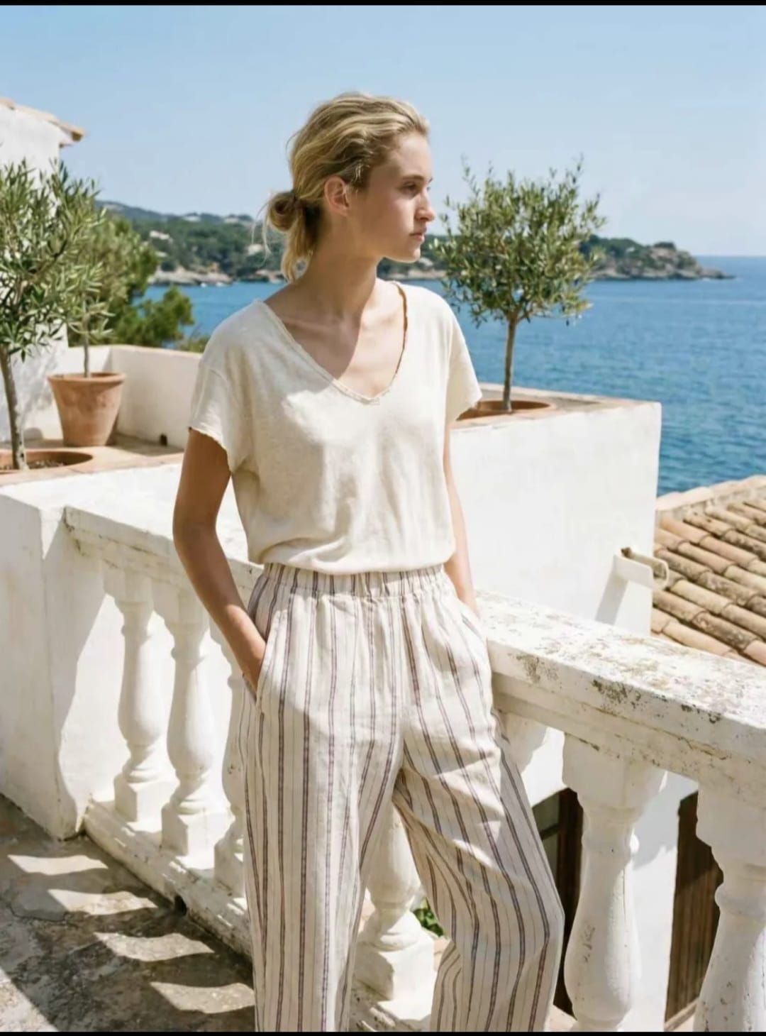 Une femme en combinaison beige se tient sur un quai portuaire