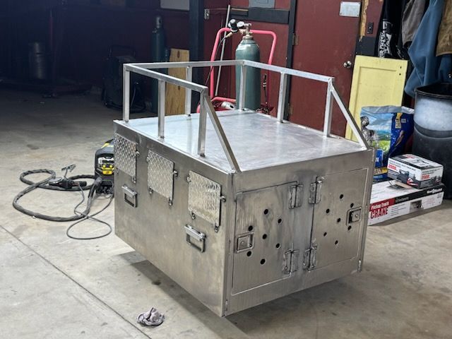 Stainless steel industrial cart with railings and a gas cylinder in a workshop garage