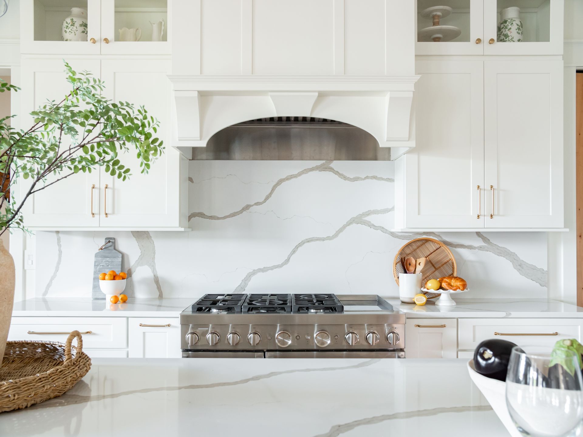 A kitchen with white cabinets and a stove top oven.