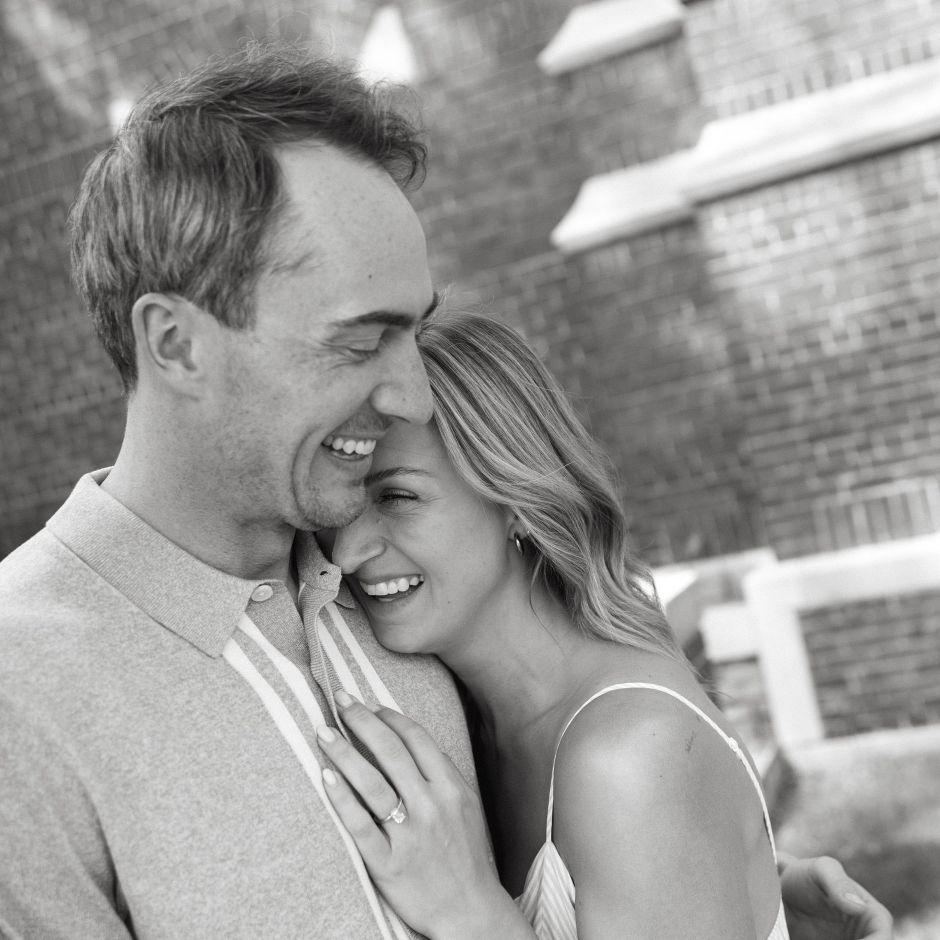 Smiling couple embracing outdoors in black and white portrait