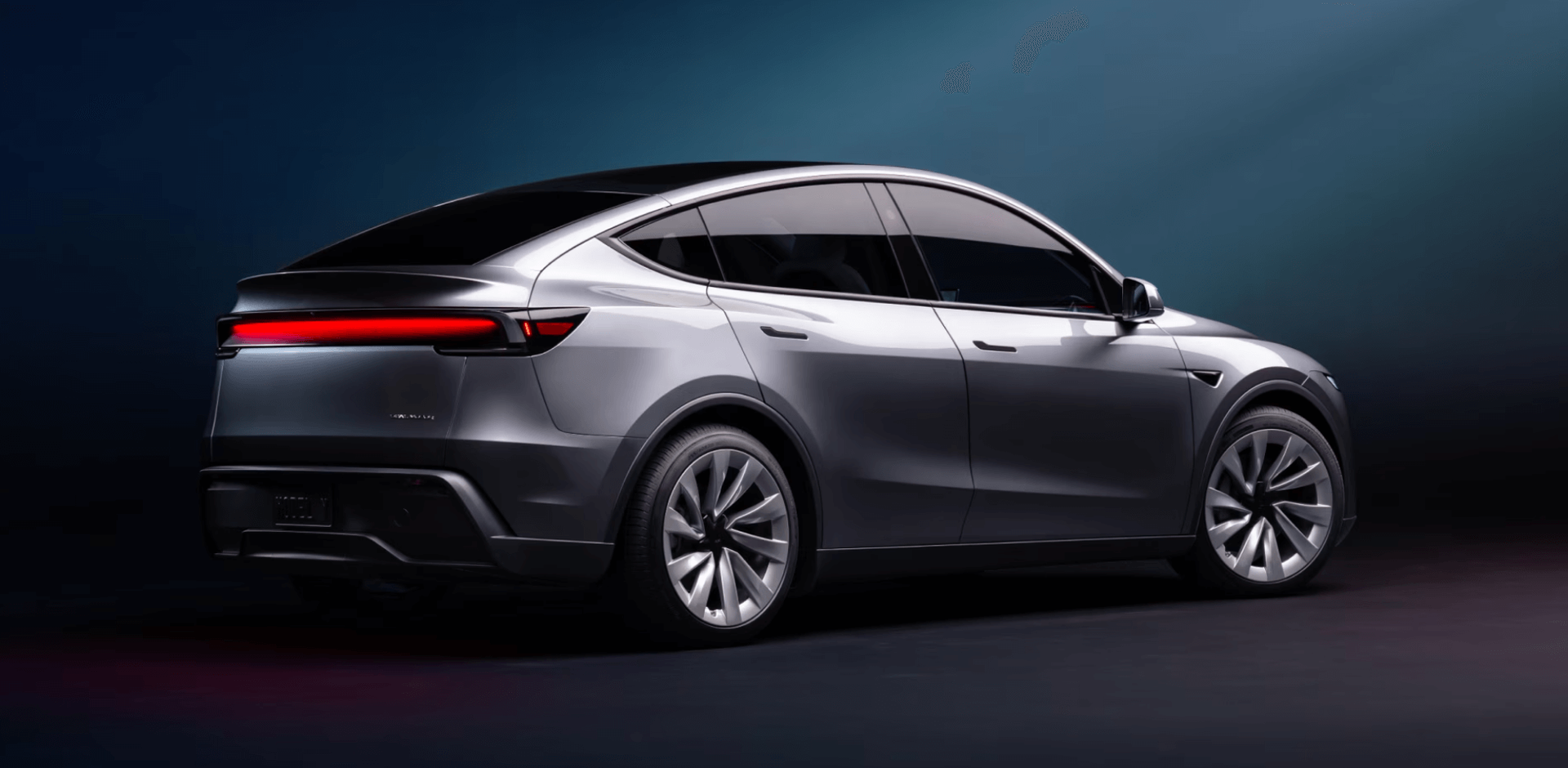 A tesla model y is parked in a dark room.
