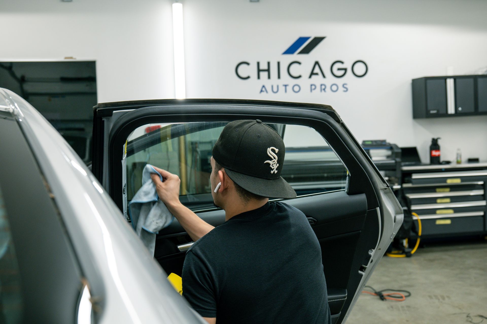 a man is cleaning the windows of a car at chicago auto pros .