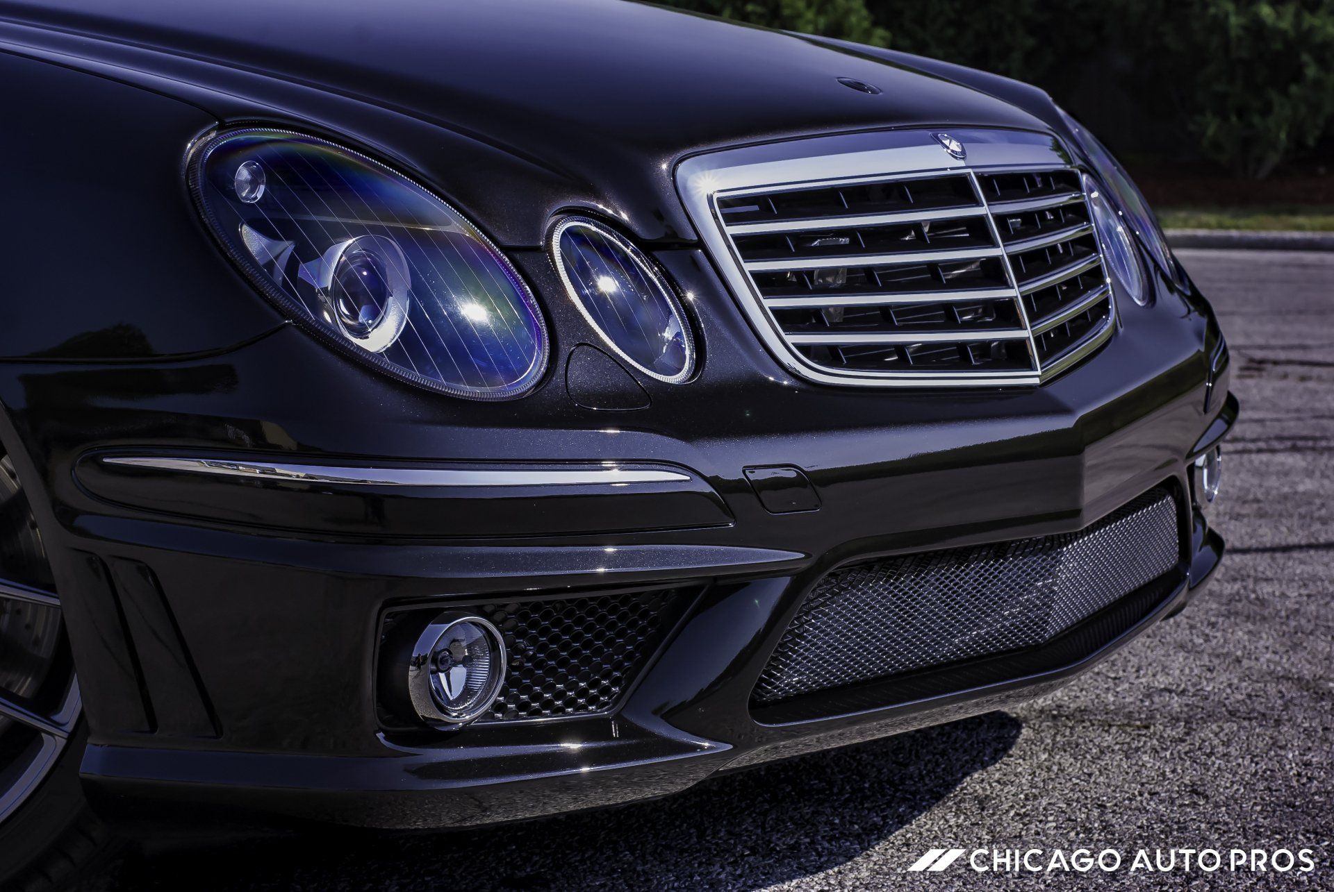 A black mercedes benz is parked on the side of the road