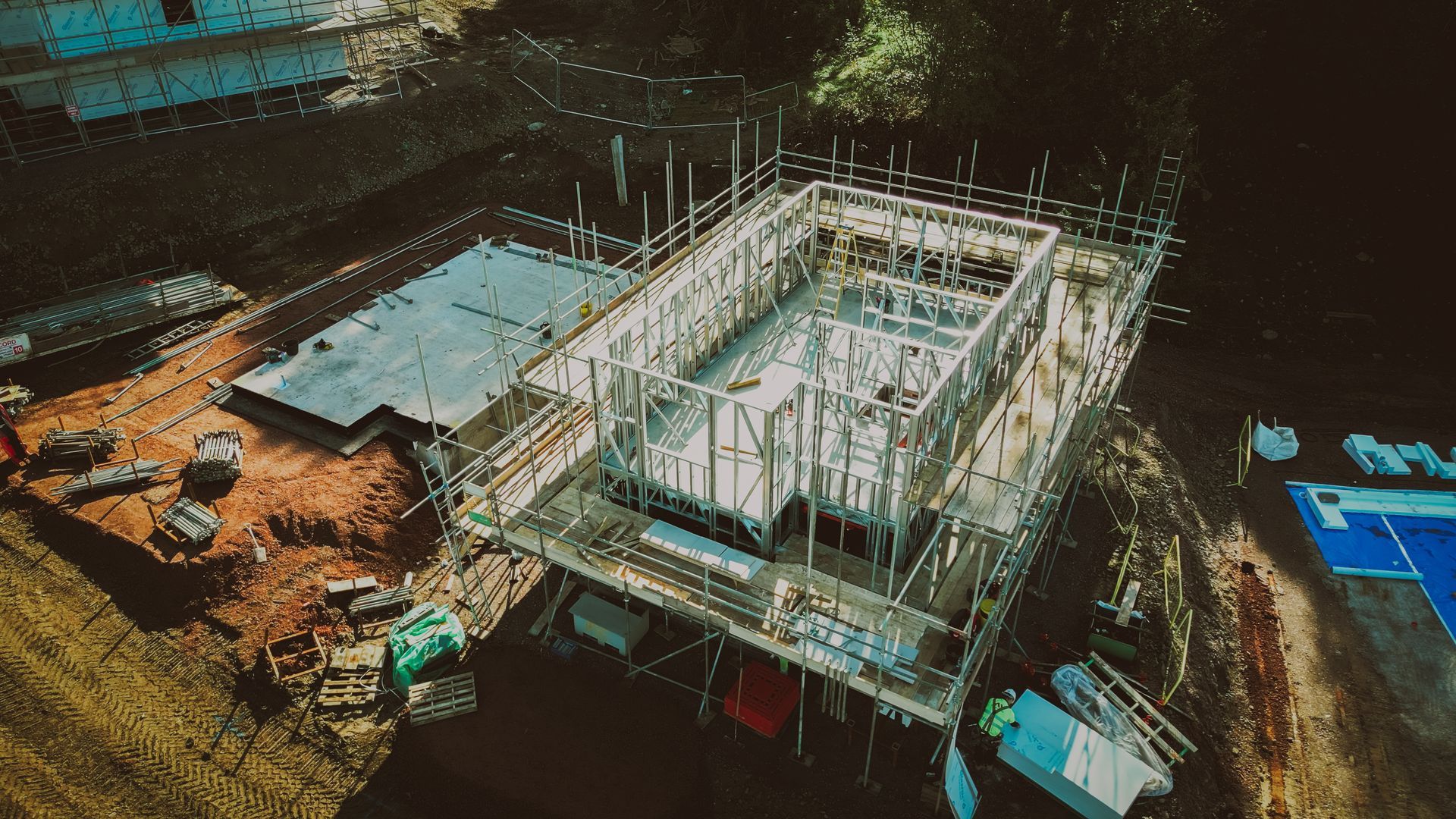 Construction site aerial view; skeletal structure of a building framed with scaffolding.
