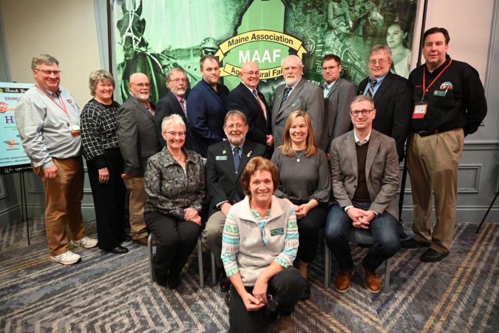A group of people posing for a photo in front of a banner for the Mid-Atlantic Association of Food Banks.