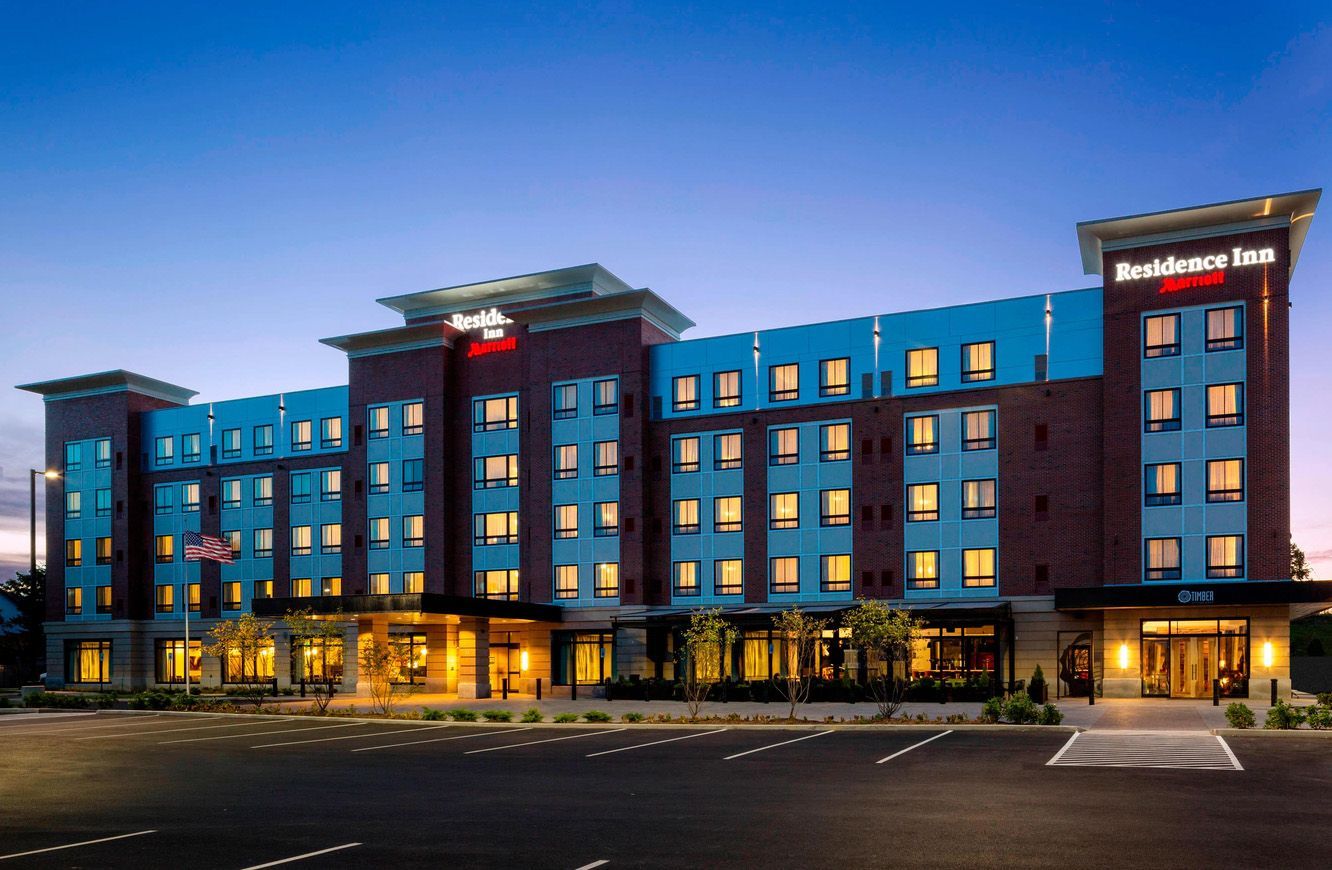 Residence Inn by Marriott hotel building at dusk, featuring a multi-story brick facade with illuminated windows.