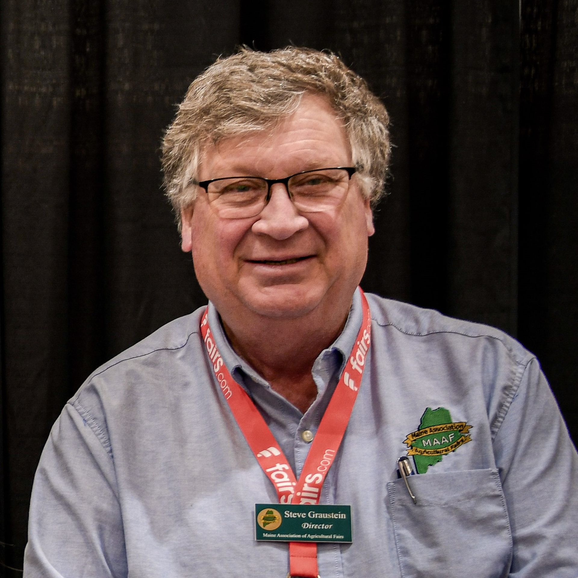 Logo for the Maine Association of Agricultural Fairs (MAAF) with the acronym over a green map of Maine on yellow ribbons.
