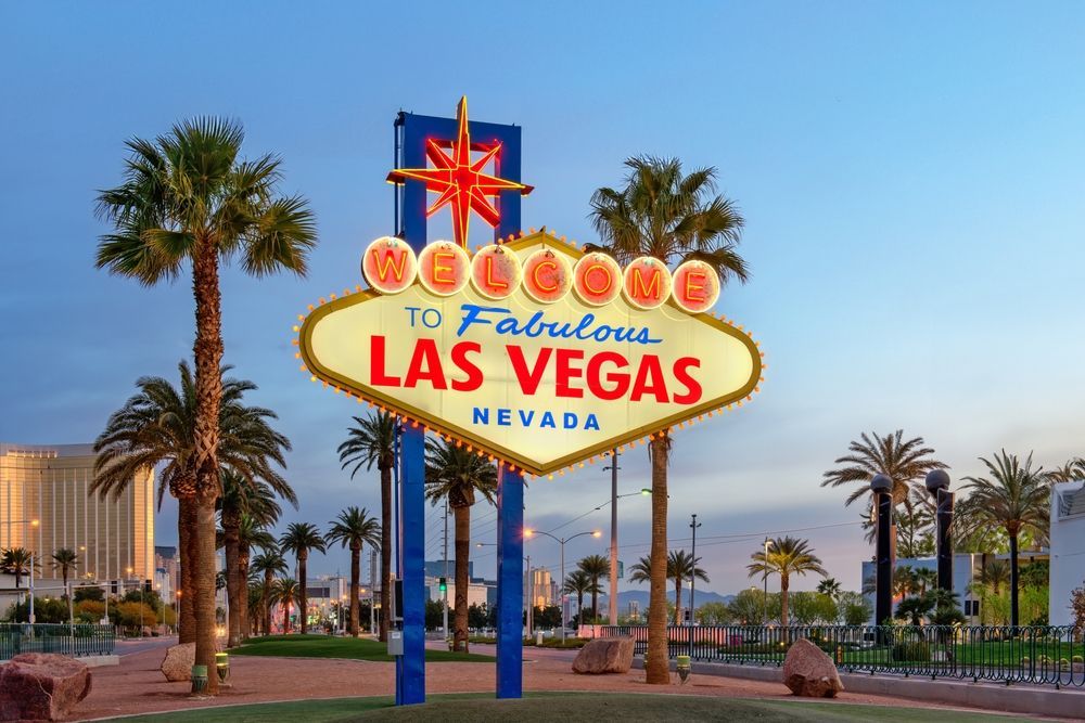 A las vegas sign with palm trees in the background