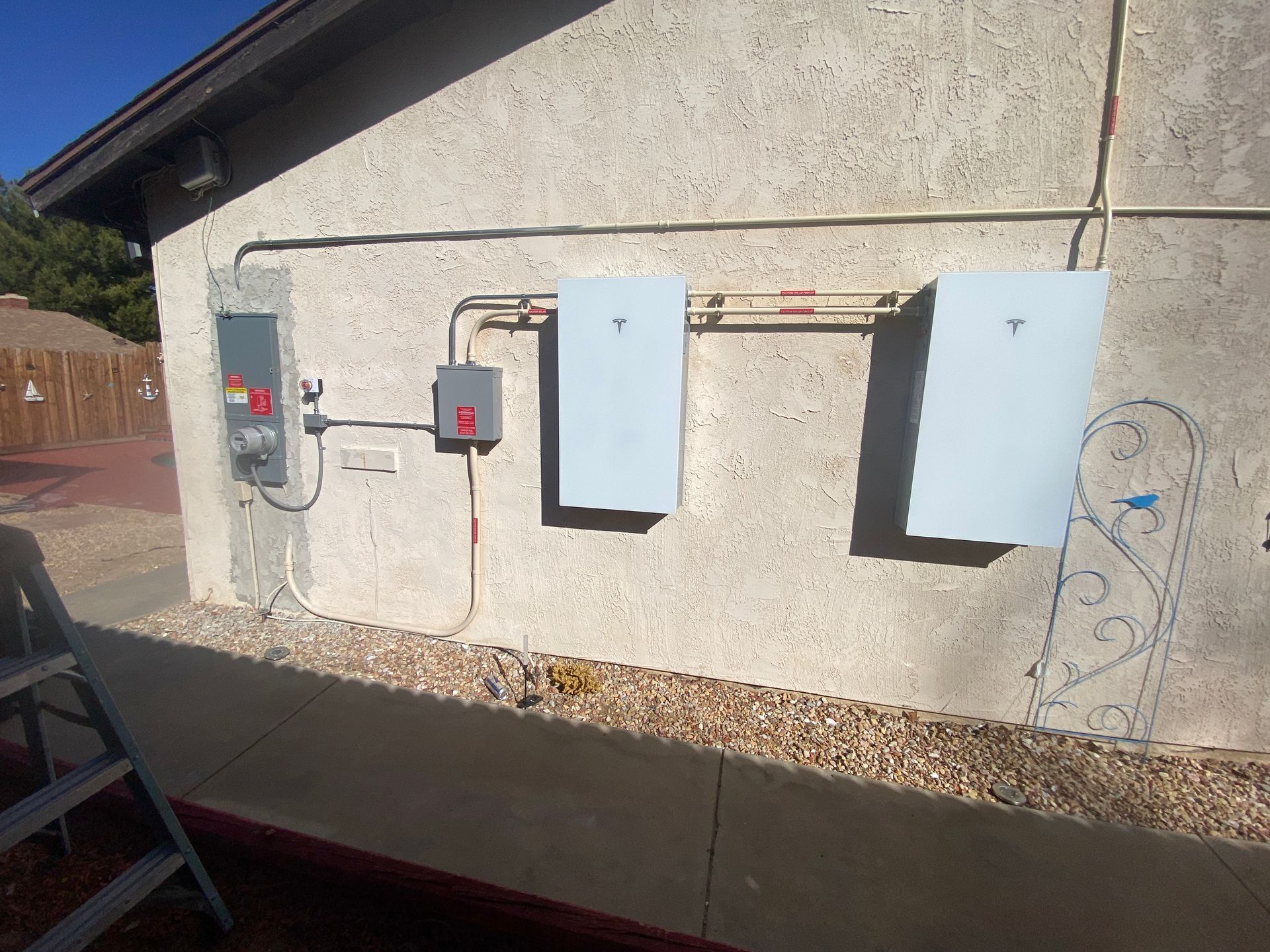 Exterior wall with electrical panels and conduit in bright sunlight