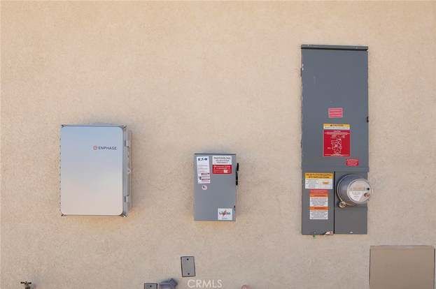 Wall-mounted utility meters and electrical boxes on a beige exterior wall