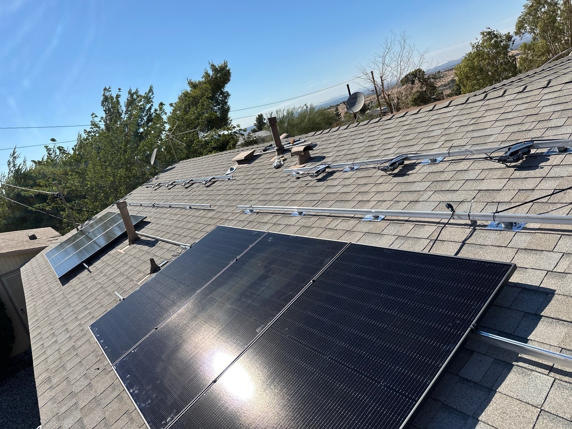 Solar panels installed on a sloped roof under a clear blue sky.