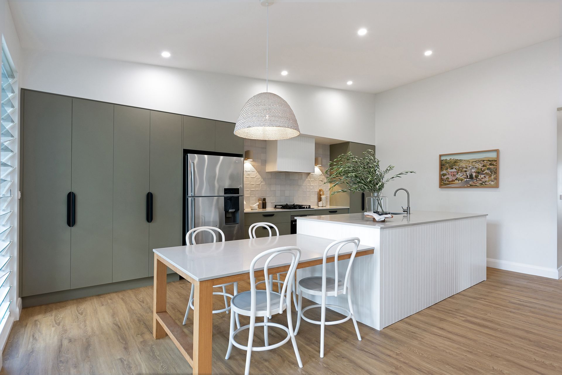 A kitchen with a table and chairs in it.