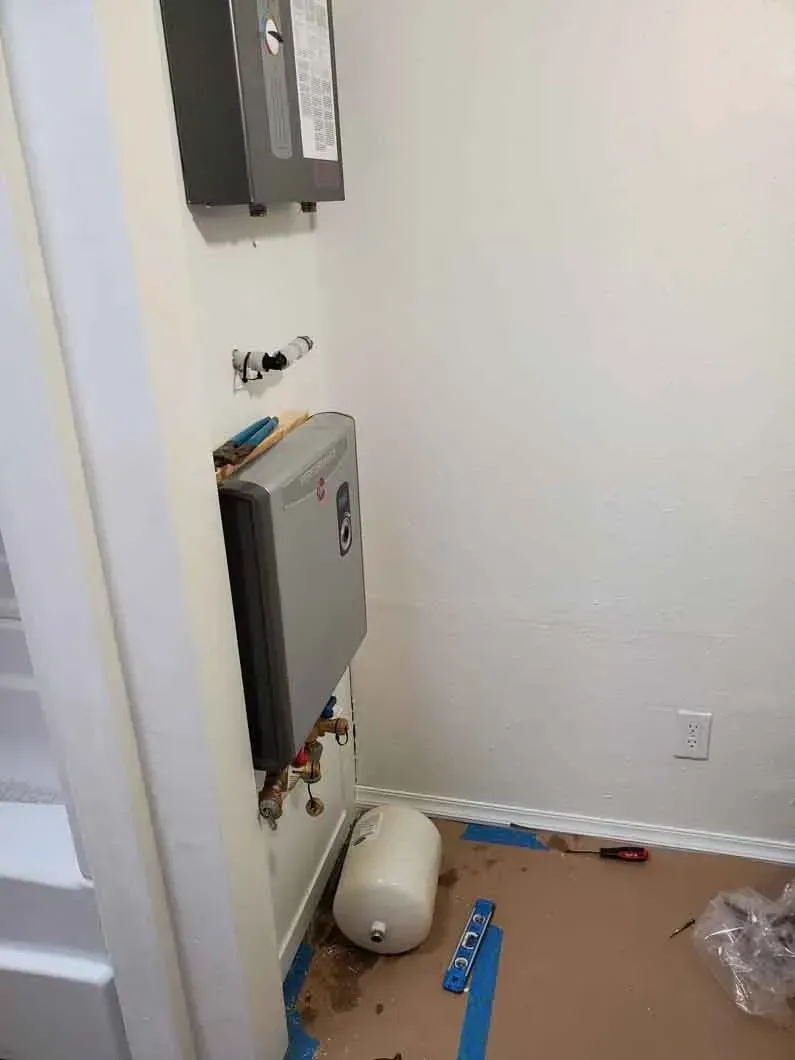 Small utility room with wall-mounted electrical panels, a floor unit, and scattered items on the floor.