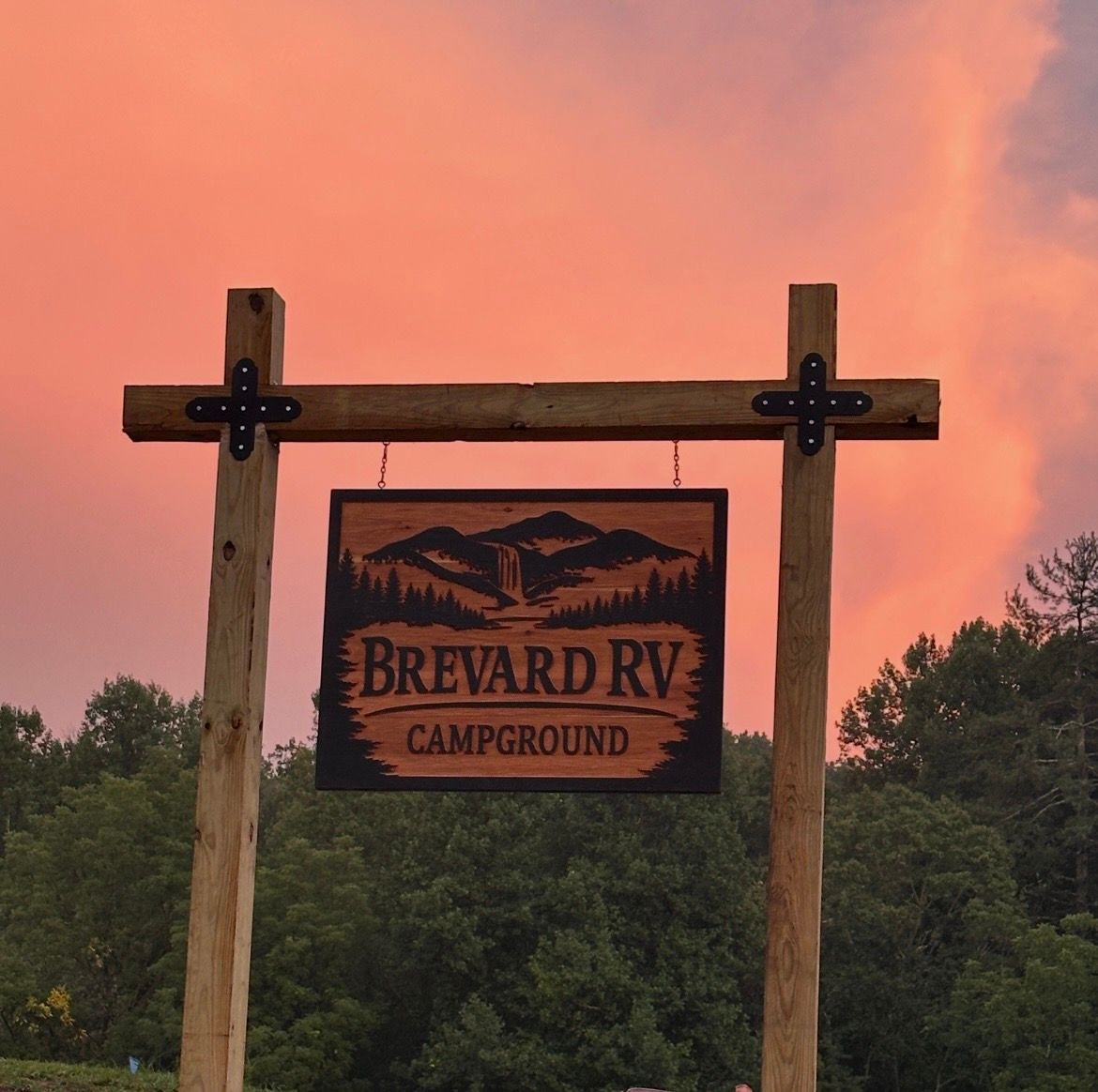 Brevard RV Campground sign against a pink sunset sky