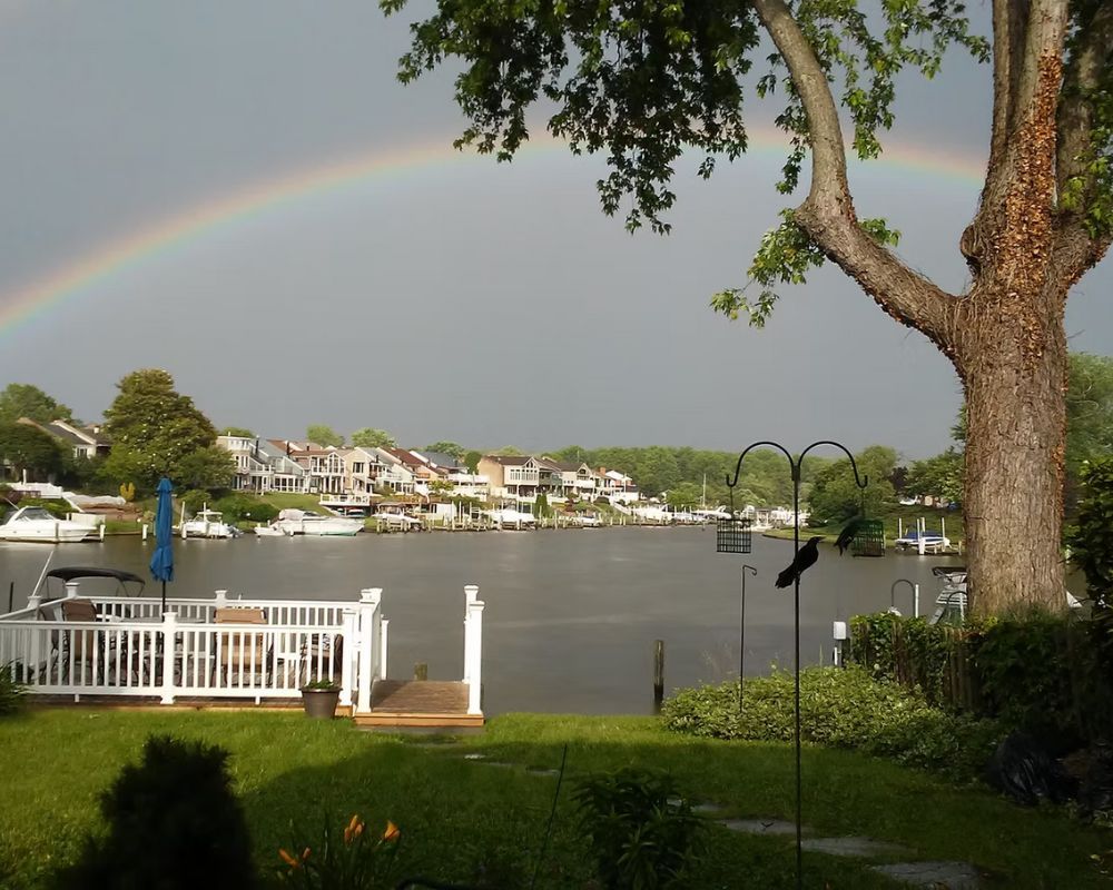 A rainbow is visible over a body of water.
