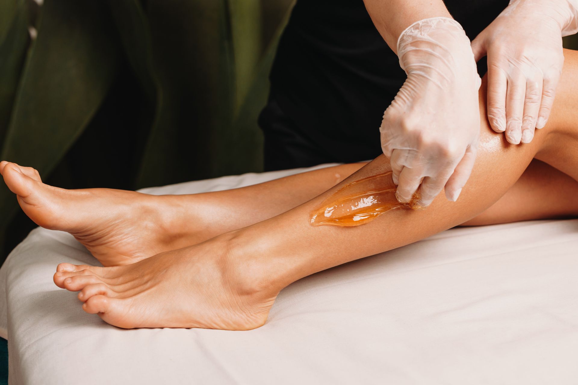 Una donna si sta facendo depilare le gambe in un salone di bellezza.