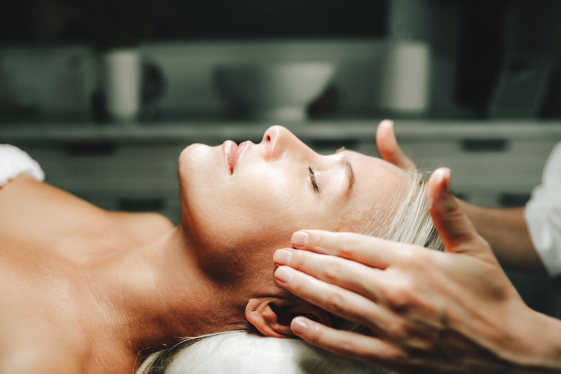 Una donna si sta facendo fare un massaggio alla testa in una spa.