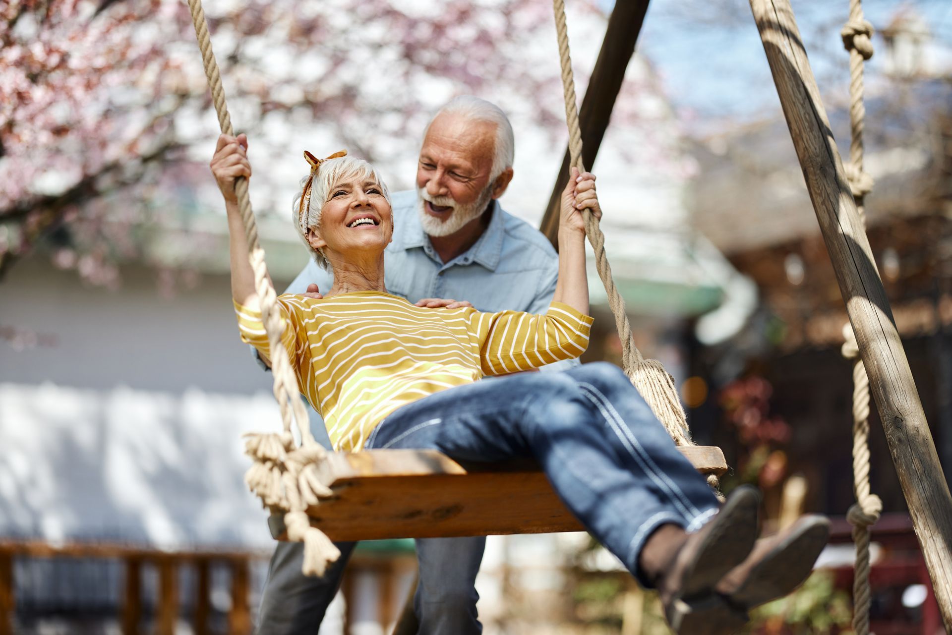 Senior couple, woman on swing, man pushing her.