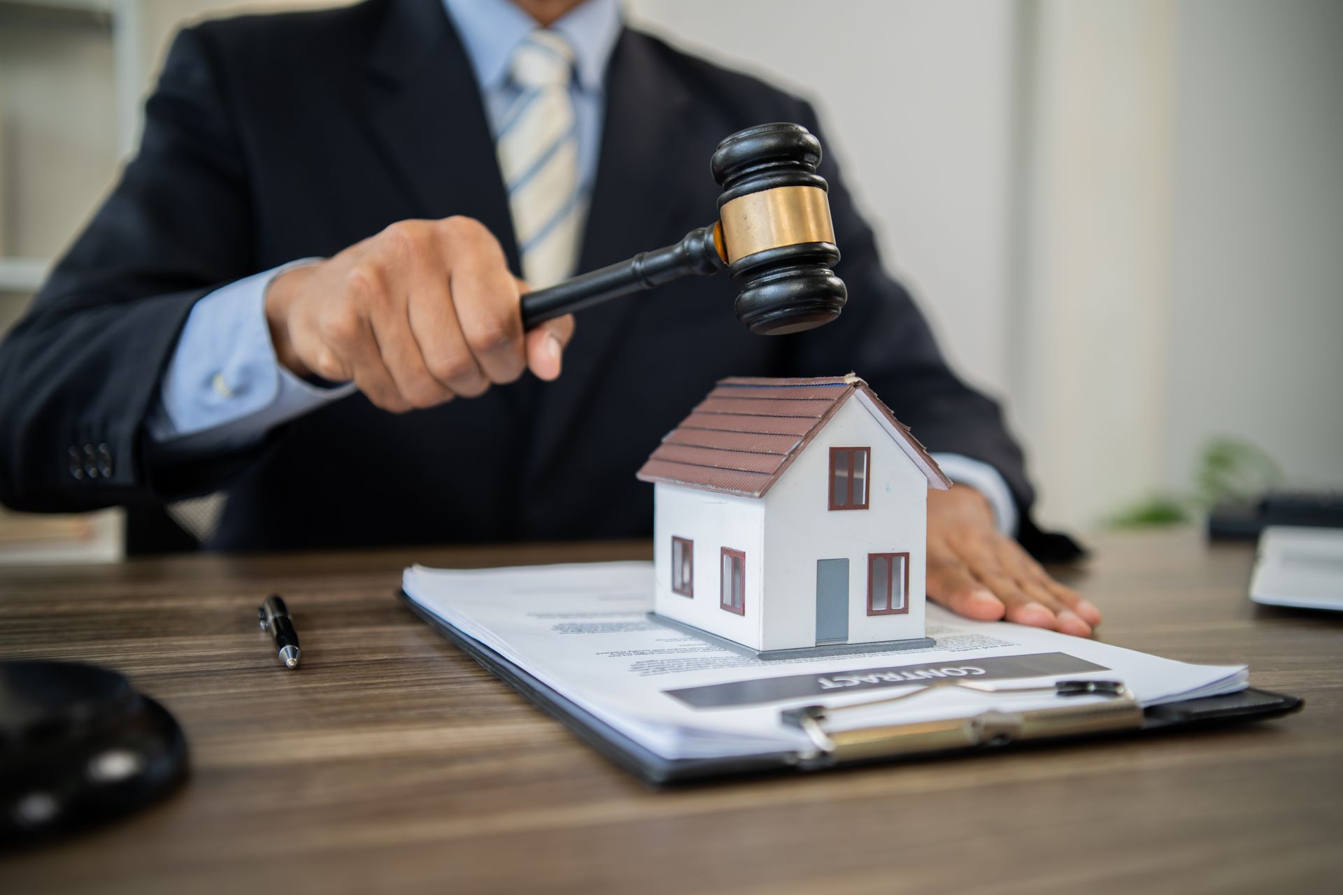 Lawyer over a model house on paperwork at a desk