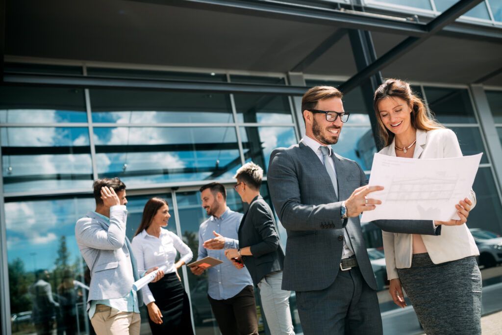 Colleagues reviewing documents outside a modern office building