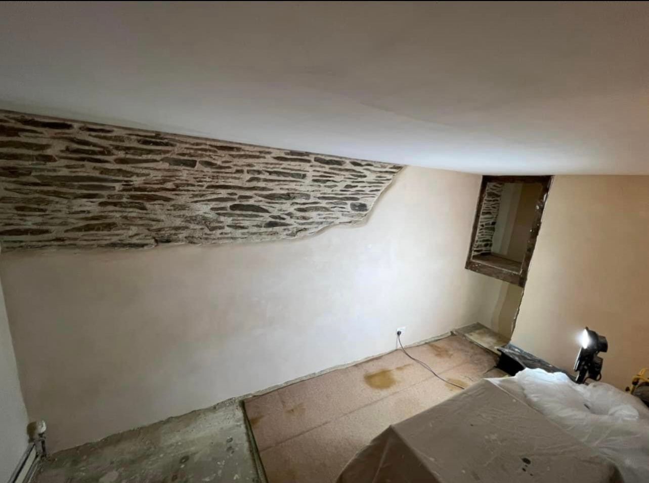 A room with a stone wall and a window.