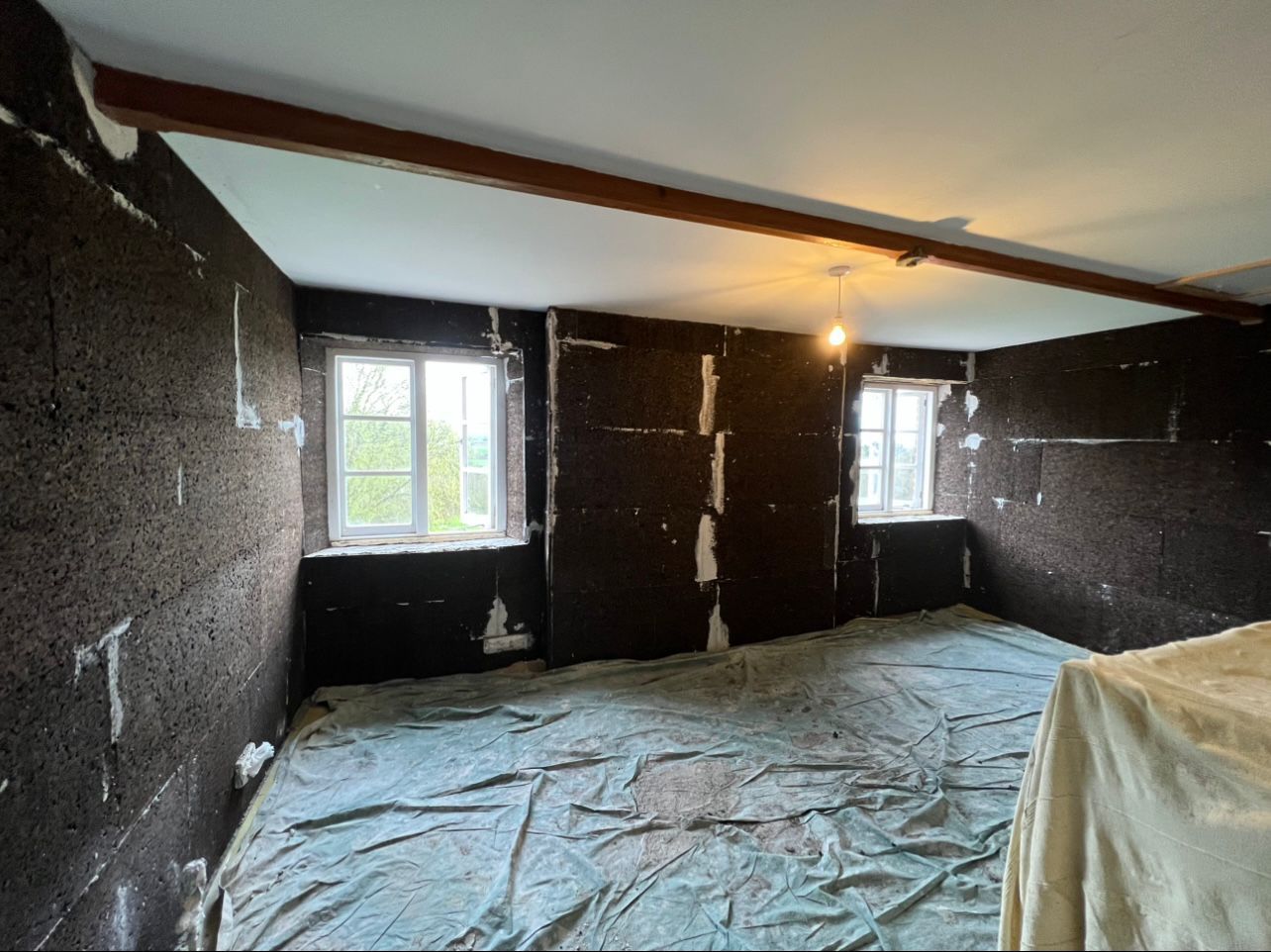 A room with a lot of windows and a blanket on the floor.