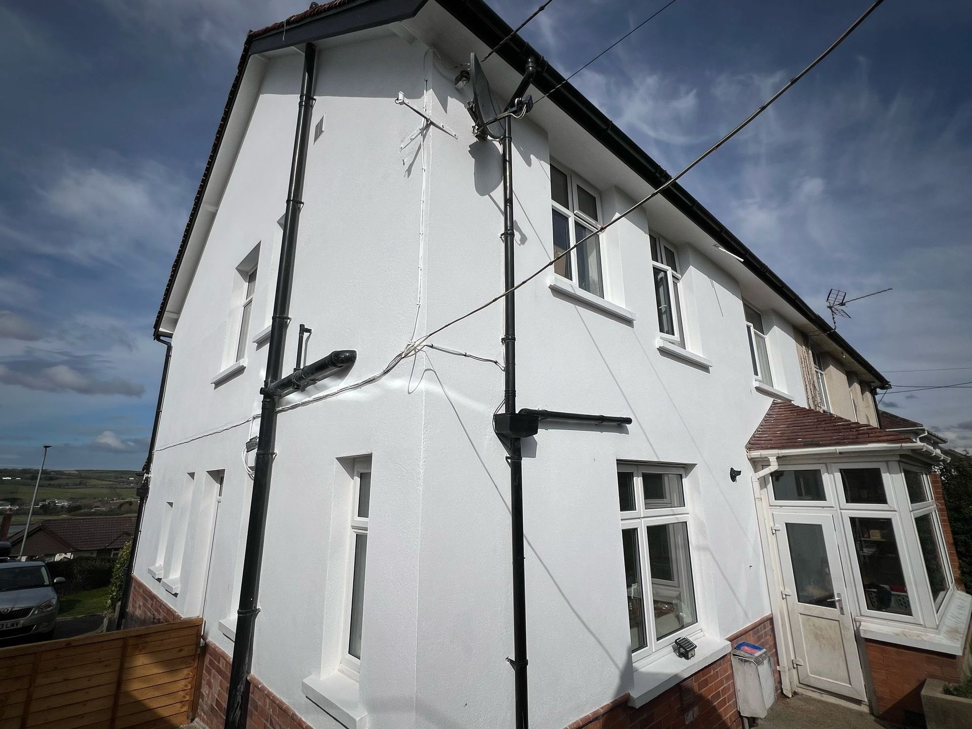 A white house with a black chimney on the roof
