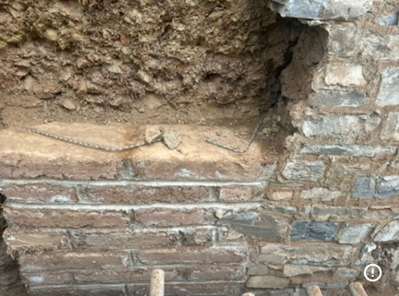 A room with a wooden floor and a stone wall.