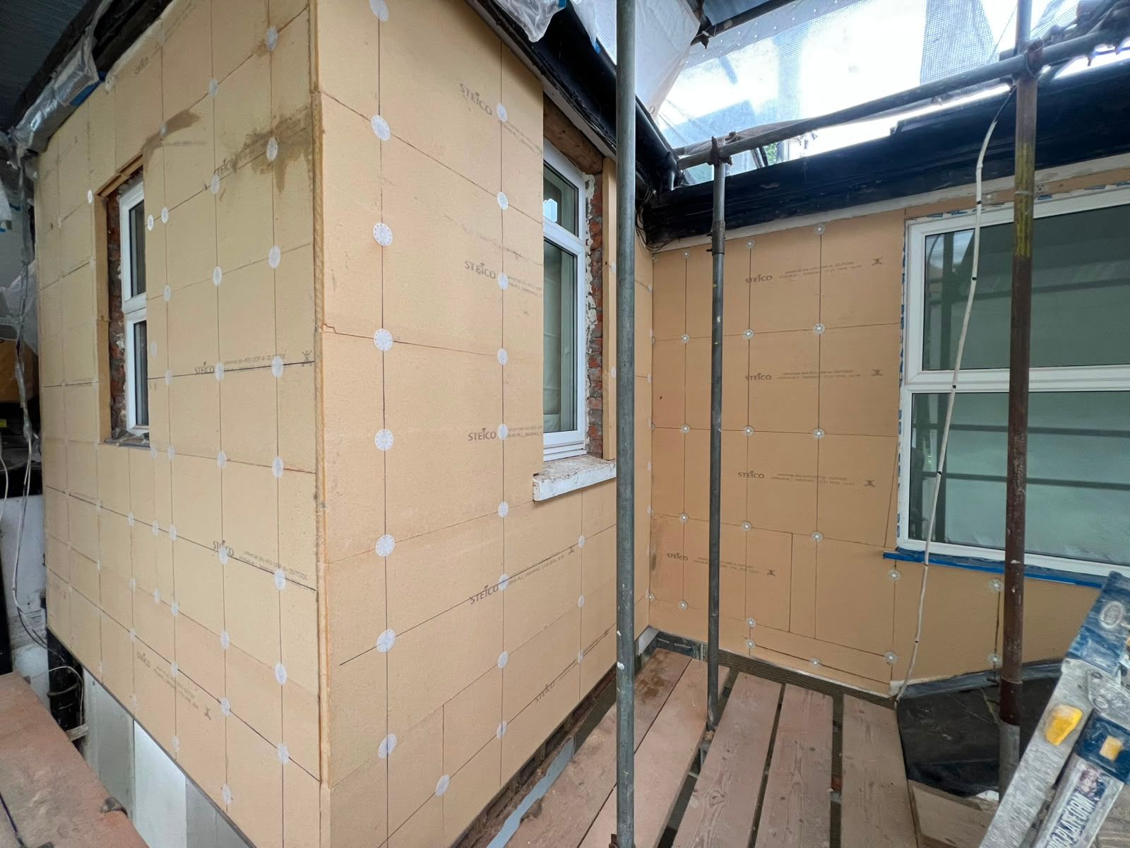 A large white house with a lot of windows is being built.