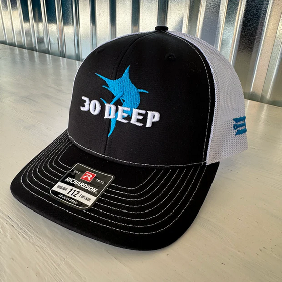 Black and white trucker hat with turquoise marlin logo and 30 DEEP text
